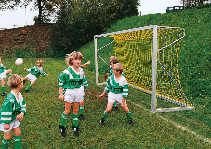 Jugendfußball-Tornetz in gelb, mit Kindern in grünen Hhuck Trikots